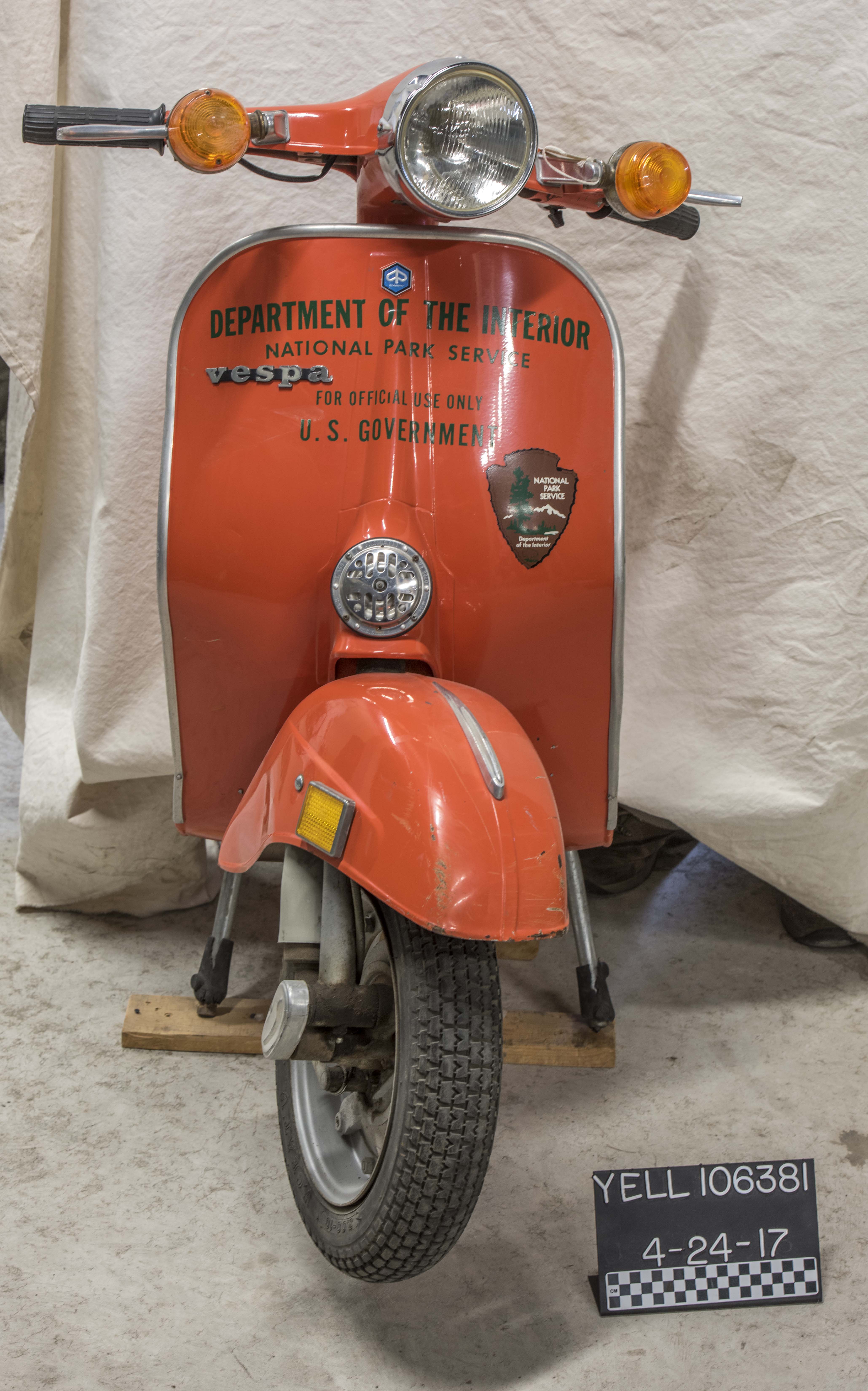 An orange scooter with Department of Interior written on the front