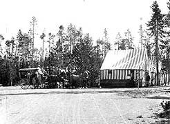 (YELL 90058-2) Shaw & Powell Camping Company group at a tent camp in Yellowstone. The Studebaker mountain stage at left is virtually identical to the example in the park's museum collection. (Montana Historical Society)