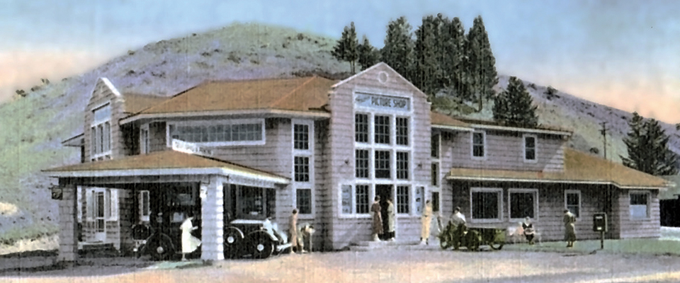 Visitors in front of a building with many windows in front of a mountain