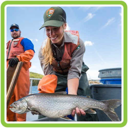A fish biologist holds a lake trout.