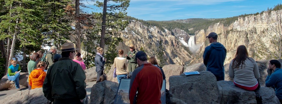 Ranger talks with visitors with the Lower Falls in the background.