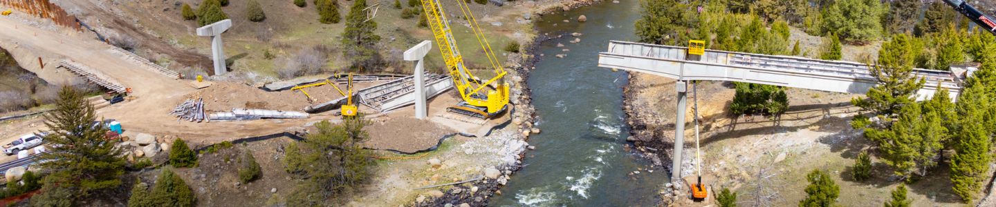 An aerial view of heavy equipment and machinery at a construction site of a new bridge