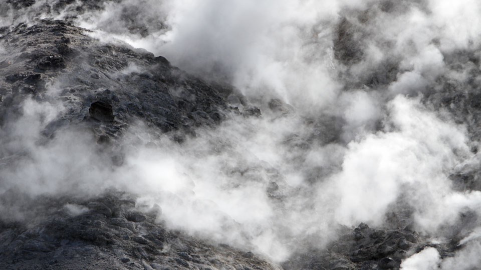 Steam rising from a rocky, barren mountainside.
