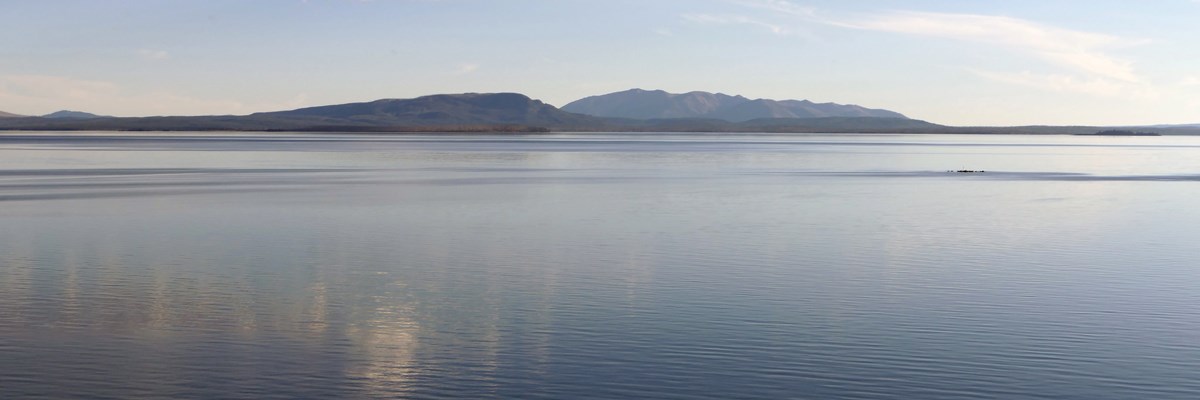 Calm waters of a large lake in front of mountains
