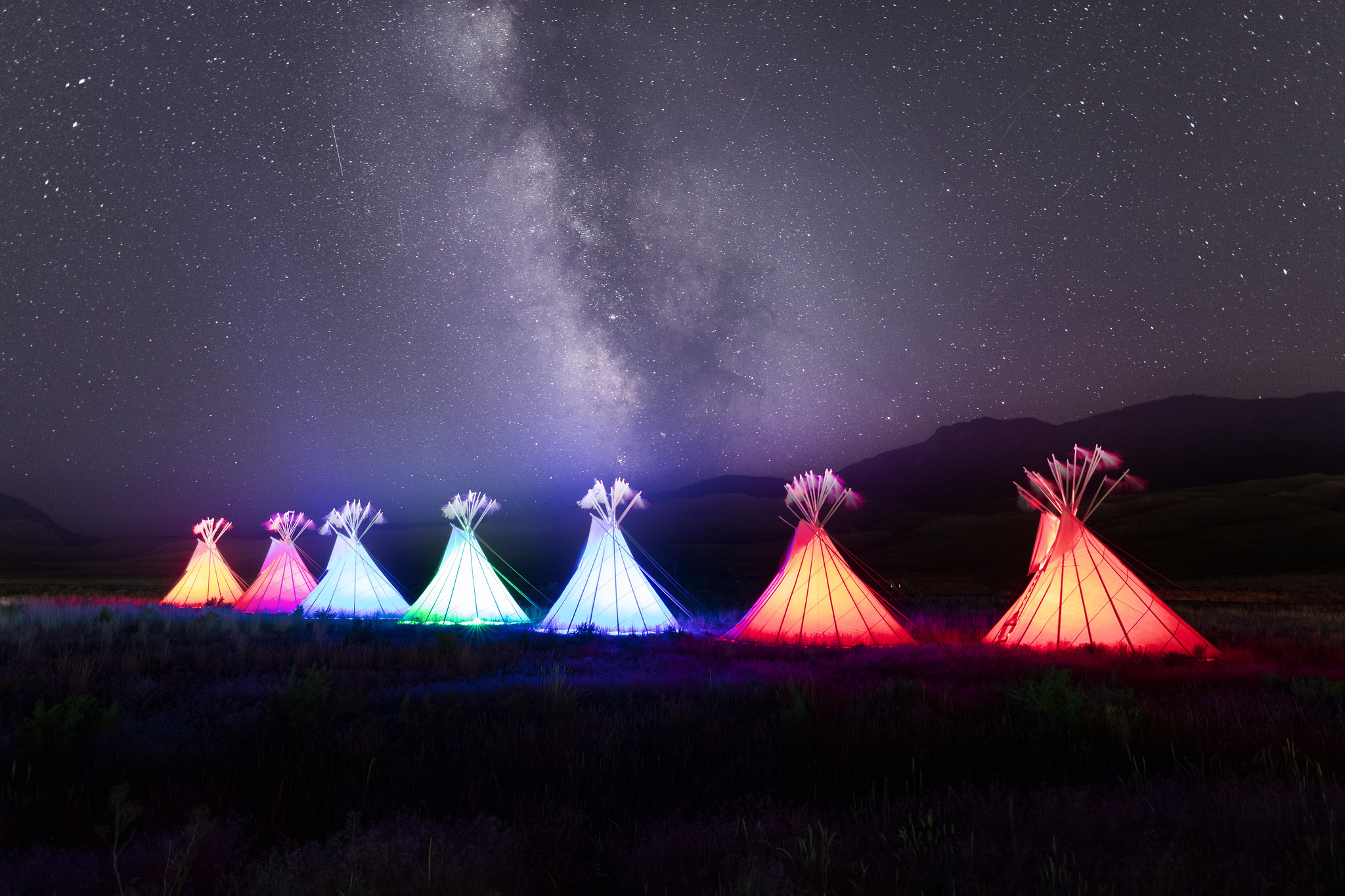 Yellowstone Revealed: illuminated teepees and Milky Way at North Entrance in Gardiner, Montana