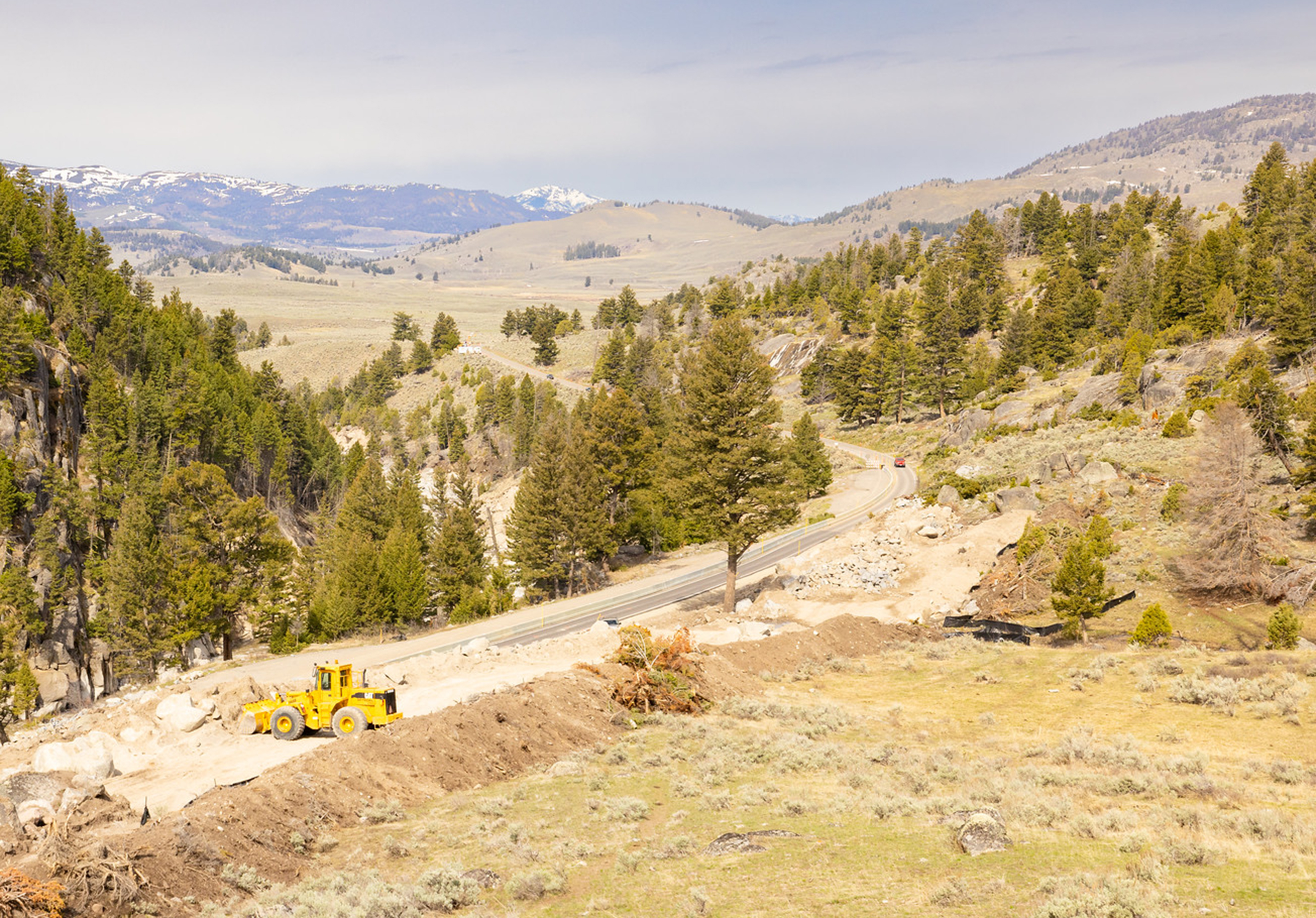 Segment of roadway under construction in forested valley