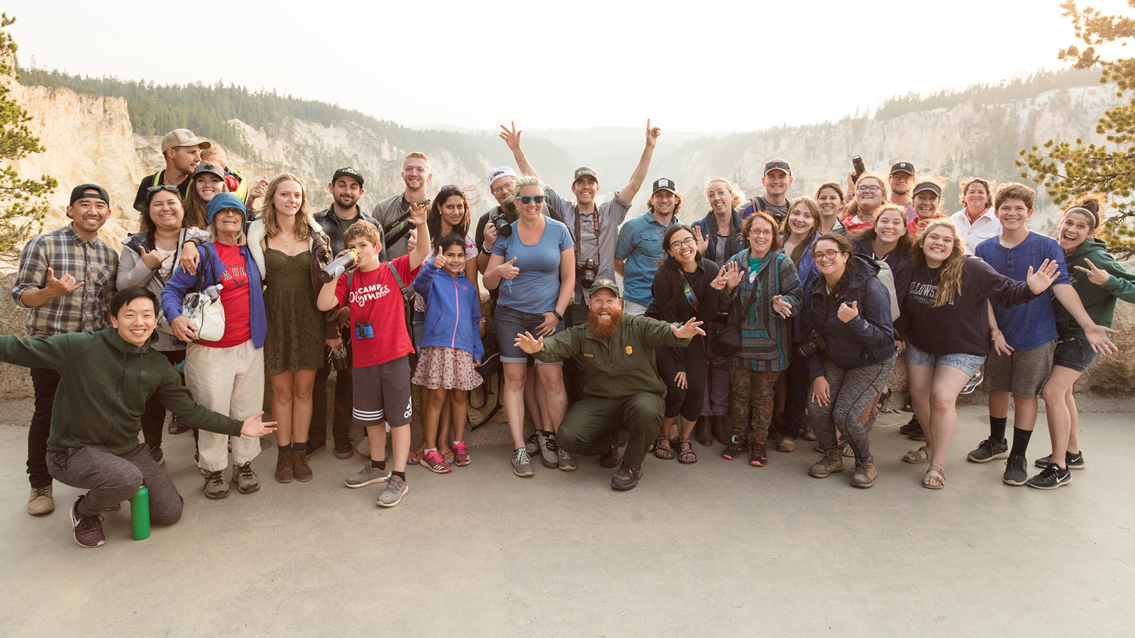 A group of people show their enthusiasm for Yellowstone by taking a group photo.
