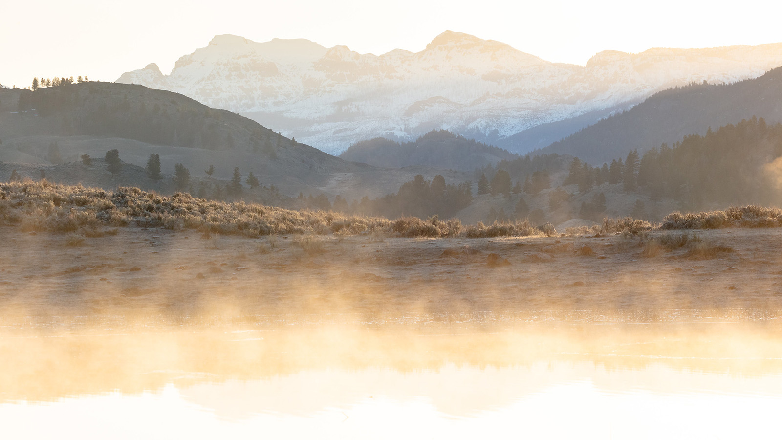 Mountains reflecting in water at sunrise