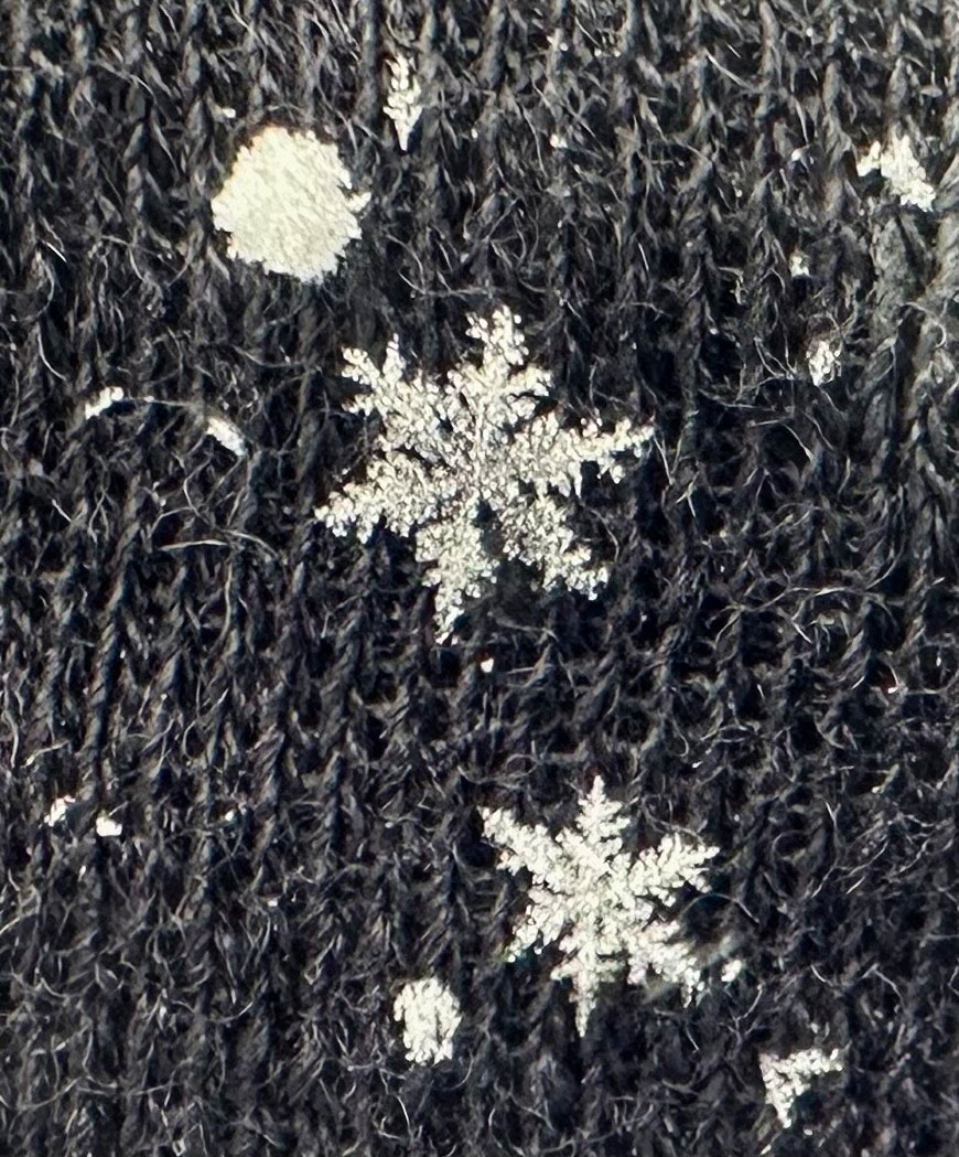 Two intricate snowflakes lying on top of cloth