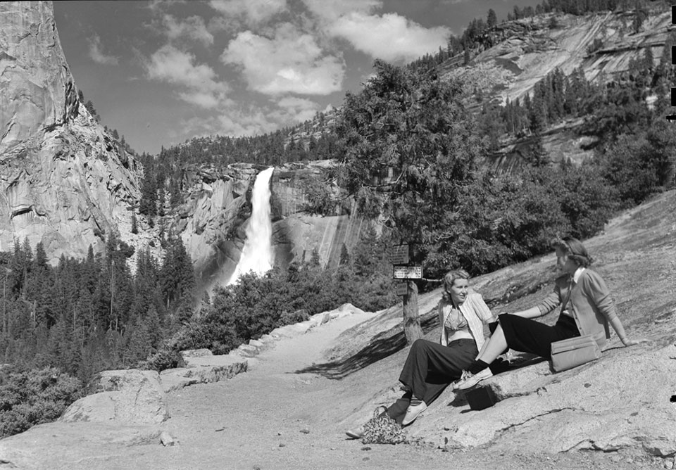 Women sitting on rock with Nevada Fall in background