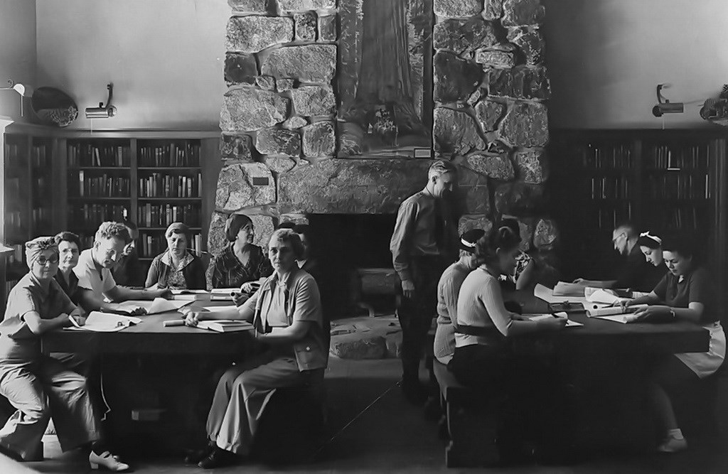 historical photograph of the Yosemite Museum Library with men and women studying.