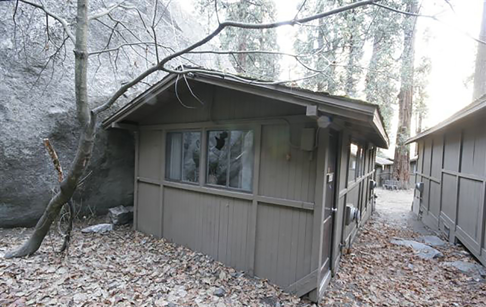 Hard sided cabin in Curry Village next to boulder that is much bigger than cabin