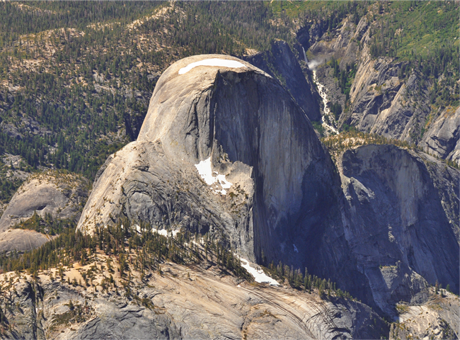 Aerial view of Half Dome, which looks like a rounded ridge with a sheer cliff on one side
