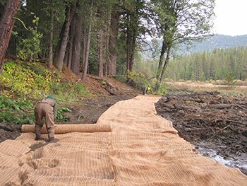NPS employee placing an erosion control blanket on the ground
