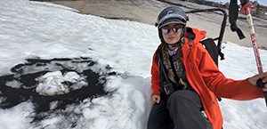 Employee setting a charcoal explosive in an avalanche zone