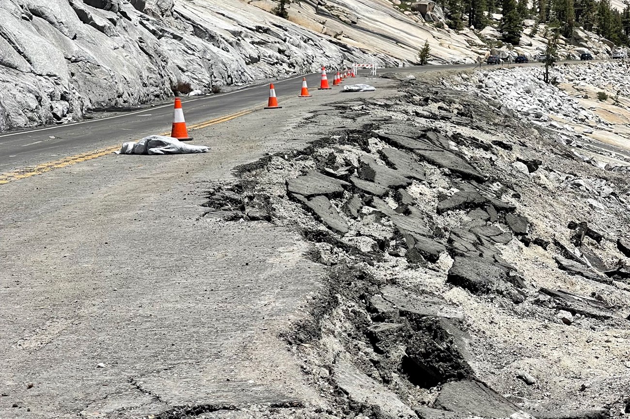 View looking down Tioga Road, with cones down the centerline and most of the downhill lane collapsed