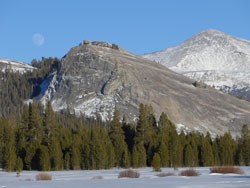 Granite dome overlooking a snowy meadow.