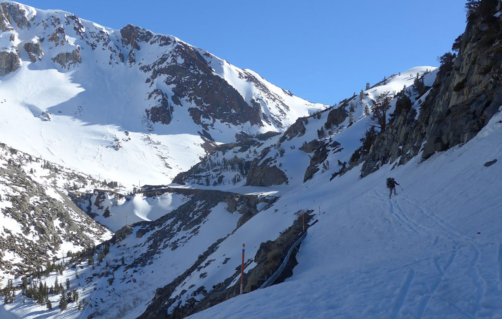 Skier along Tioda Road on April 29, 2017 near Green Bridge. There are exposed cliffs below guardrails.