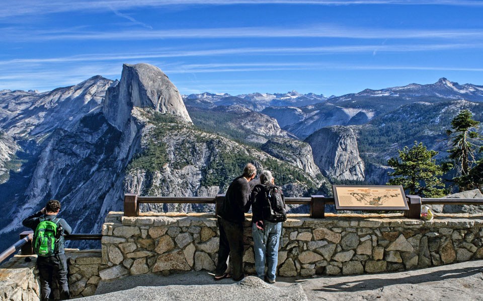 People looking out from Glacier Point towards Half Dome.