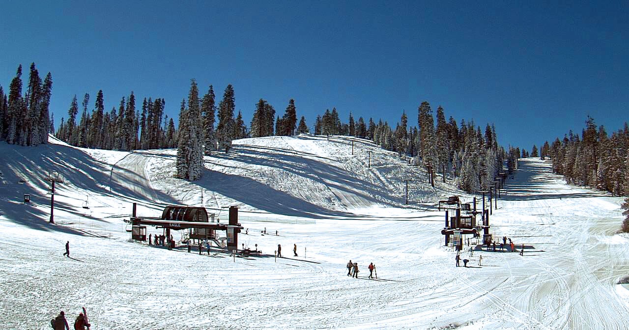 Badger Pass on opening day in 2015, clear blue skies, skiers, ski lifts