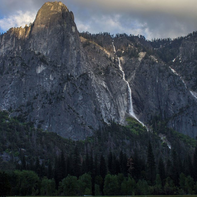 Sentinel Falls and Sentinel Rock with a meadow in the foreground