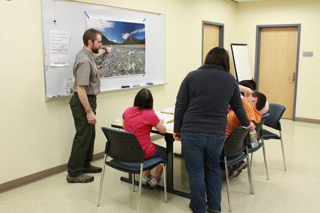 Park Ranger shows a large image of a river to a group of young students