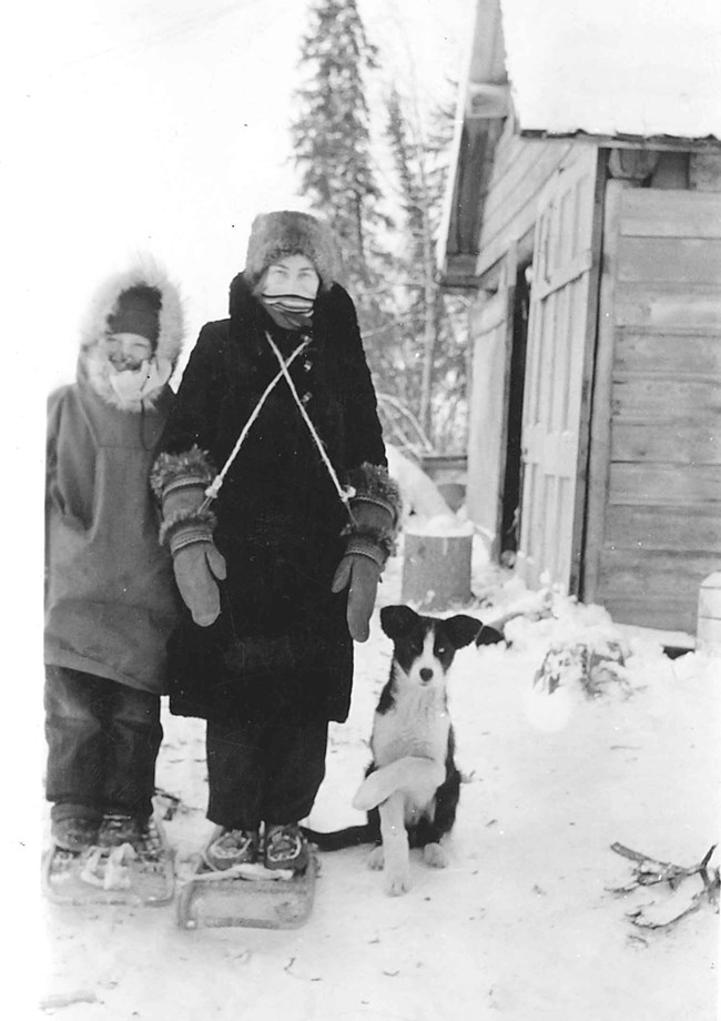 Mildred and Al Hendricks Jr with sled dog Taku in winter