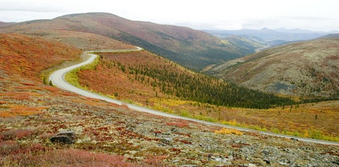 The Top of the World highway winds across barren, tundra covered highlands.