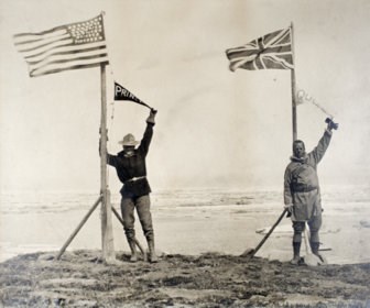 Historic photo of the American and Canadian survey team leaders celebrating the end of the line at the Arctic Ocean.