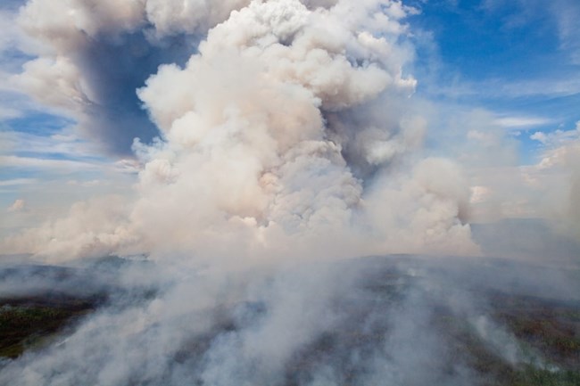 A wildfire sends smoke up thousands of feet above the Yukon River hills.