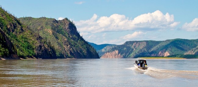 A visitor's boat motors downriver from Slaven's Roadhouse area on the Yukon River