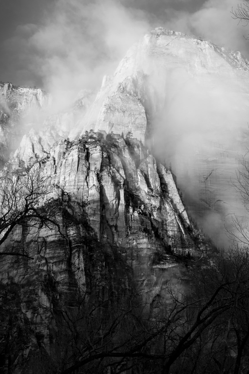Black and white photograph of canyon walls and clouds.