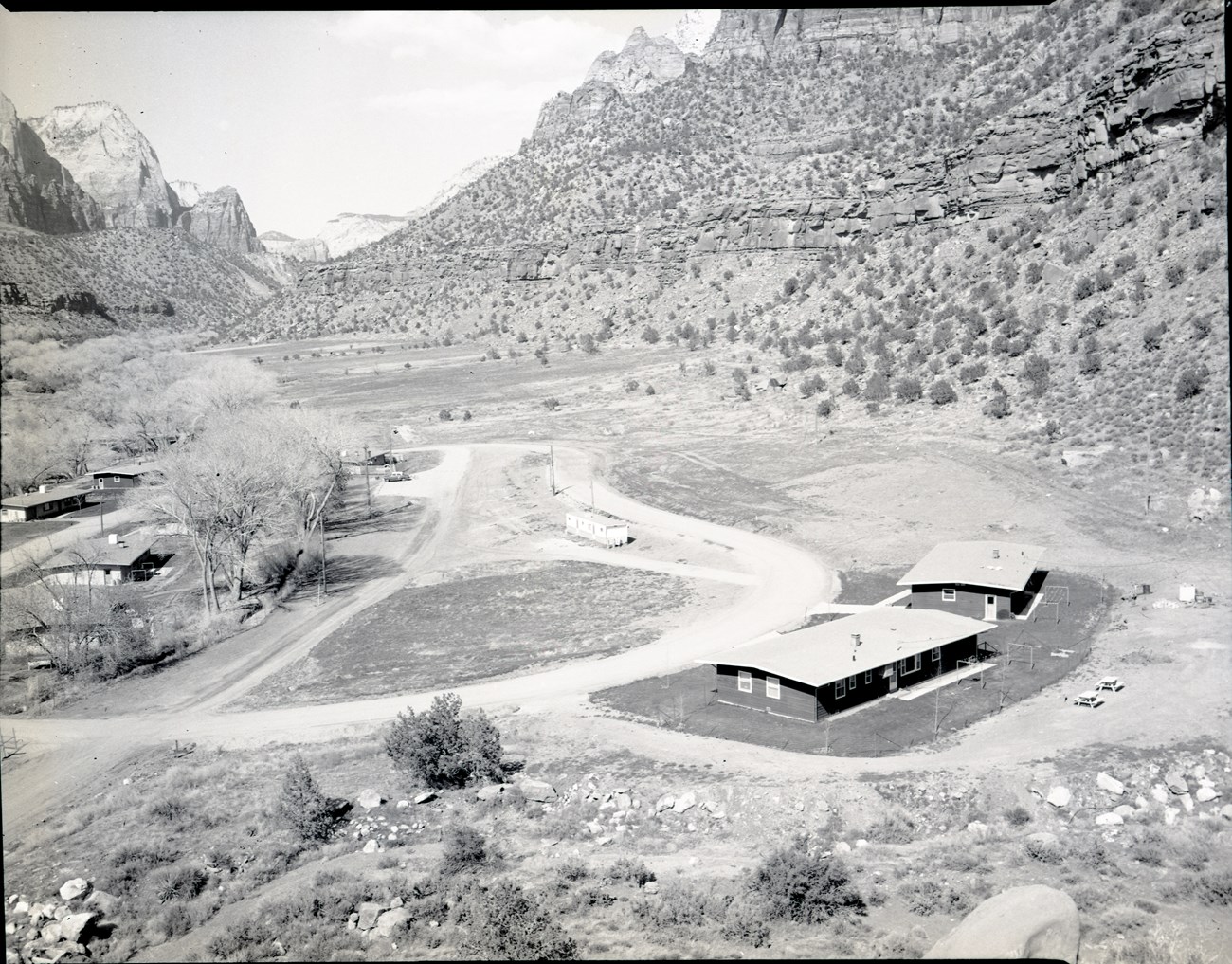 ZION 7832: After the end of the CCC program, the area where Camp NP-4 stood was leveled and turned into the Watchman residential area for National Park Service staff, pictured in this 1966 photo.