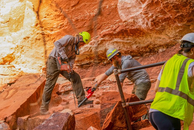 Workers drilling into a rock